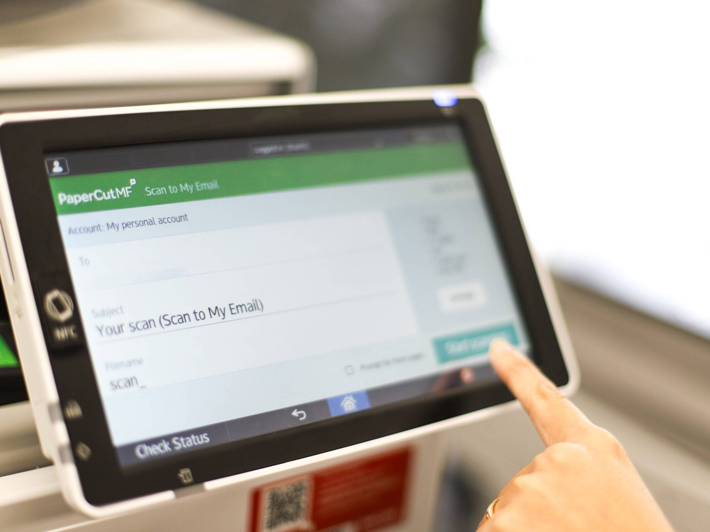 A person using PaperCut on an MFD's touch screen
